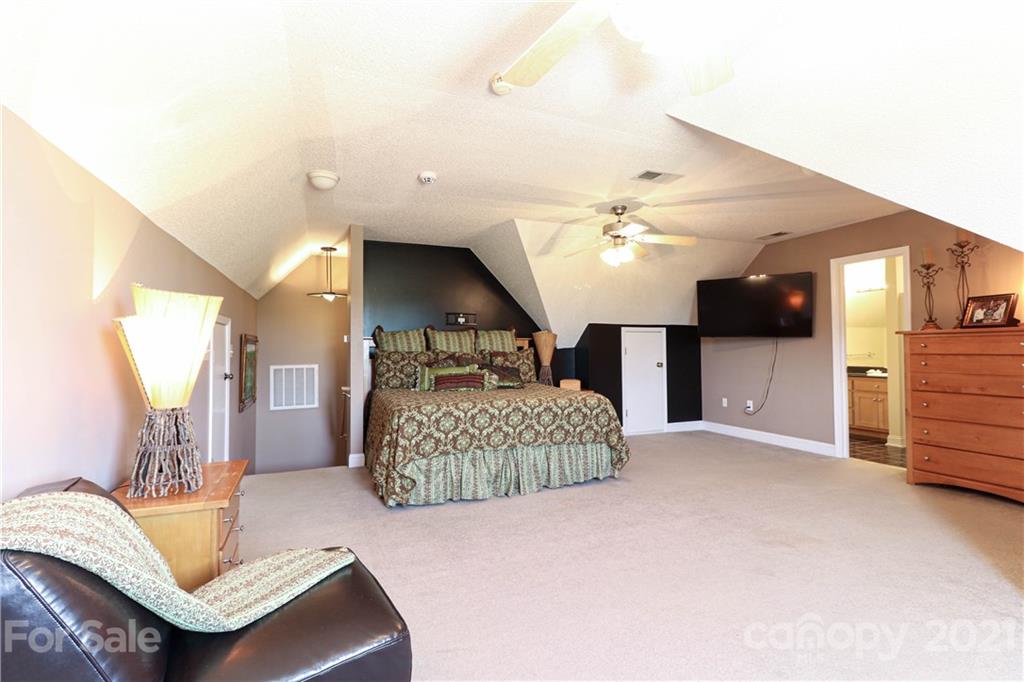 6023 Olive Branch Road Wingate, NC 28174 - Photo 33 of 44 a living room with furniture a chandelier and a flat screen tv