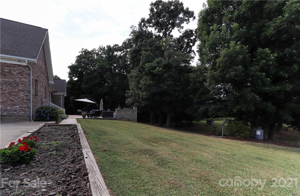 6023 Olive Branch Road Wingate, NC 28174 - Photo 40 of 44 a view of a backyard with potted plants and large trees