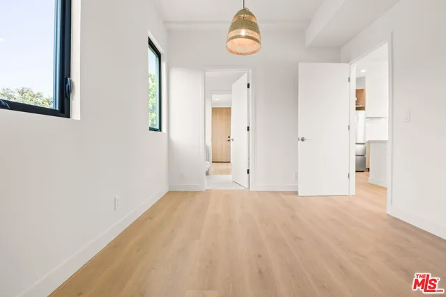 a view of a room with wooden floor and white walls