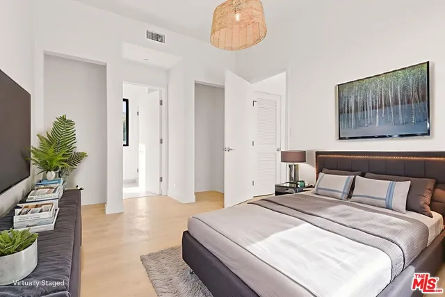 a bedroom with a bed and a potted plant