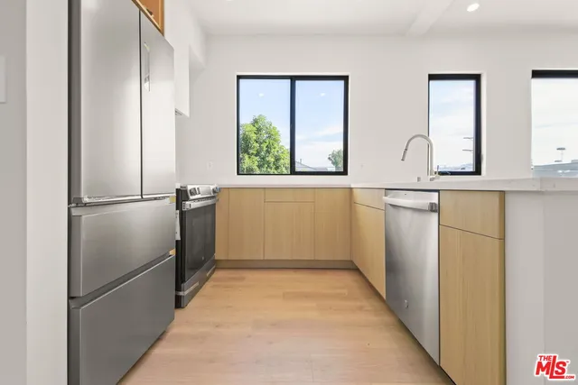 a kitchen with stainless steel appliances granite countertop a refrigerator and a sink