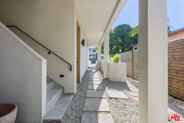 a view of a hallway to a livingroom with furniture and stairs