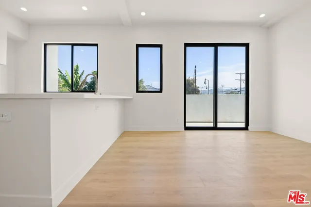 a view of an empty room with window and bathroom