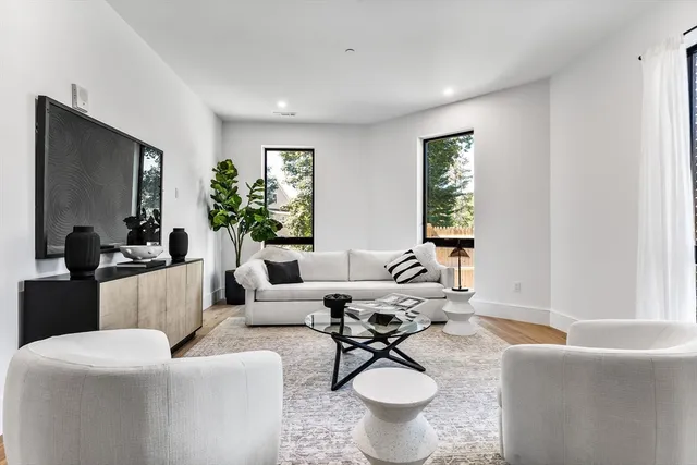a living room with furniture a window and a flat screen tv