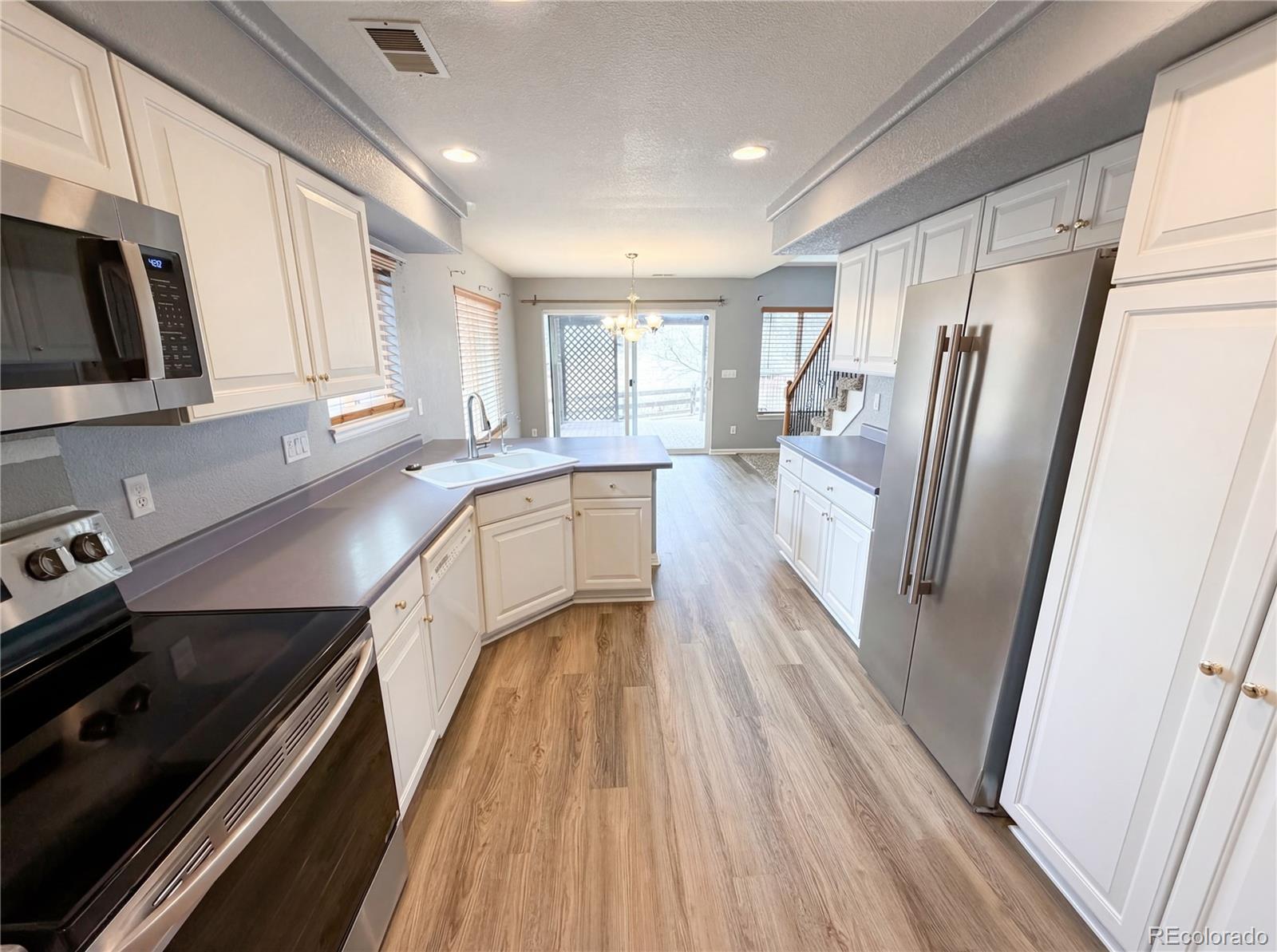 20000 Mitchell Place, Unit 45 Denver, CO 80249 - Photo 15 of 29 a kitchen with granite countertop a refrigerator stove and sink