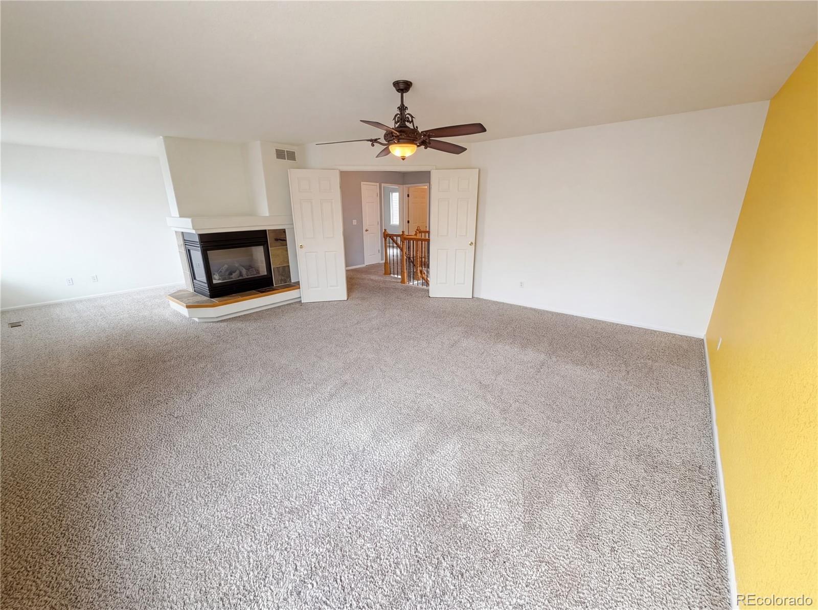 20000 Mitchell Place, Unit 45 Denver, CO 80249 - Photo 19 of 29 a view of a livingroom with a fireplace a chandelier fan and windows