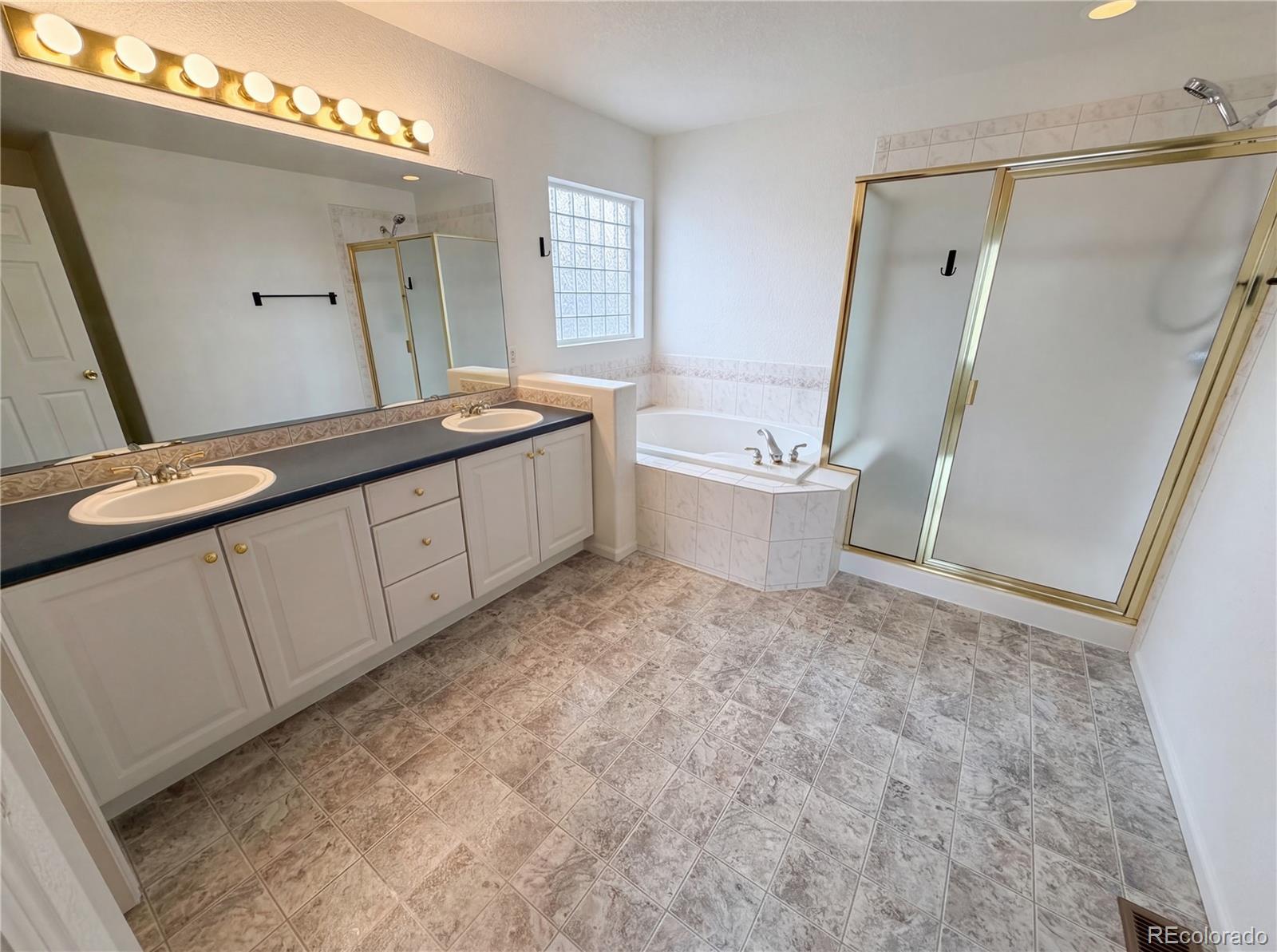 20000 Mitchell Place, Unit 45 Denver, CO 80249 - Photo 6 of 29 a spacious bathroom with a granite countertop sink a toilet a mirror and shower