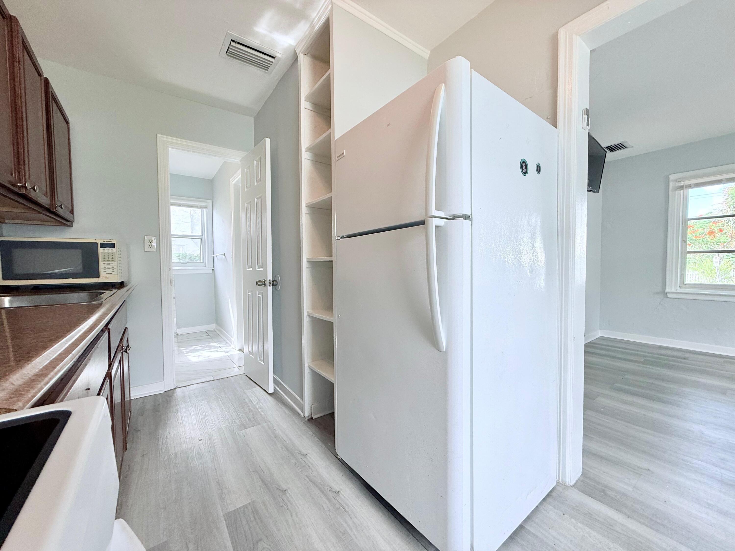 517 Kanuga Drive, Unit 1 West Palm Beach, FL 33401 - Photo 12 of 13 a view of kitchen with stainless steel appliances refrigerator stove microwave and cabinets