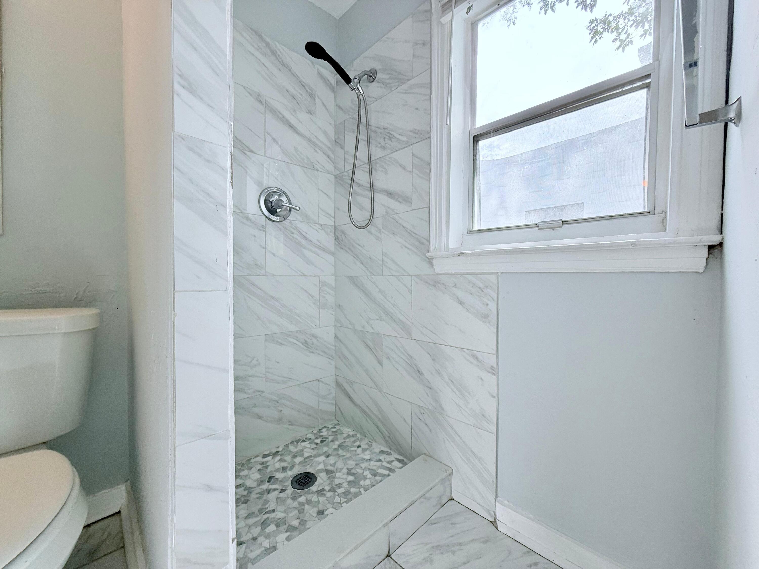 517 Kanuga Drive, Unit 1 West Palm Beach, FL 33401 - Photo 7 of 13 a bathroom with a toilet and a shower