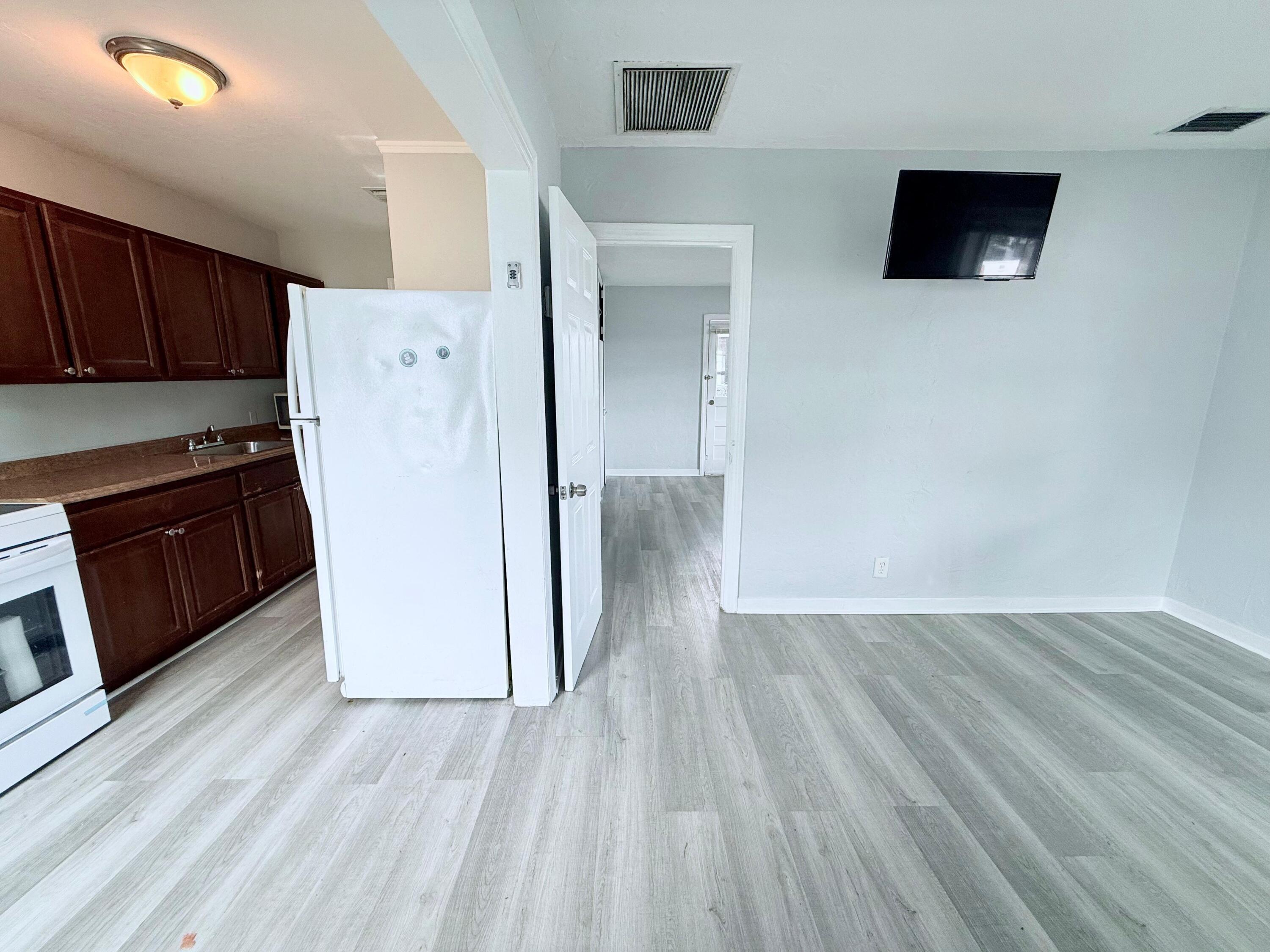 517 Kanuga Drive, Unit 1 West Palm Beach, FL 33401 - Photo 9 of 13 a view of a kitchen with wooden floor and a refrigerator