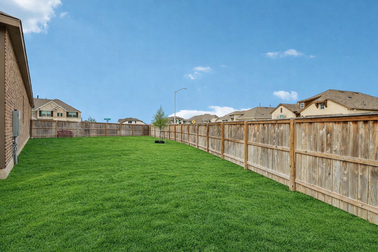 291 Billowing Way Kyle, TX 78640 - Photo 18 of 20 a view of a green field with wooden fence