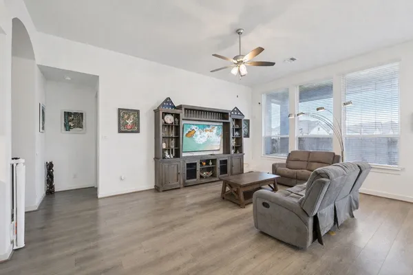 a living room with furniture and a wooden floor