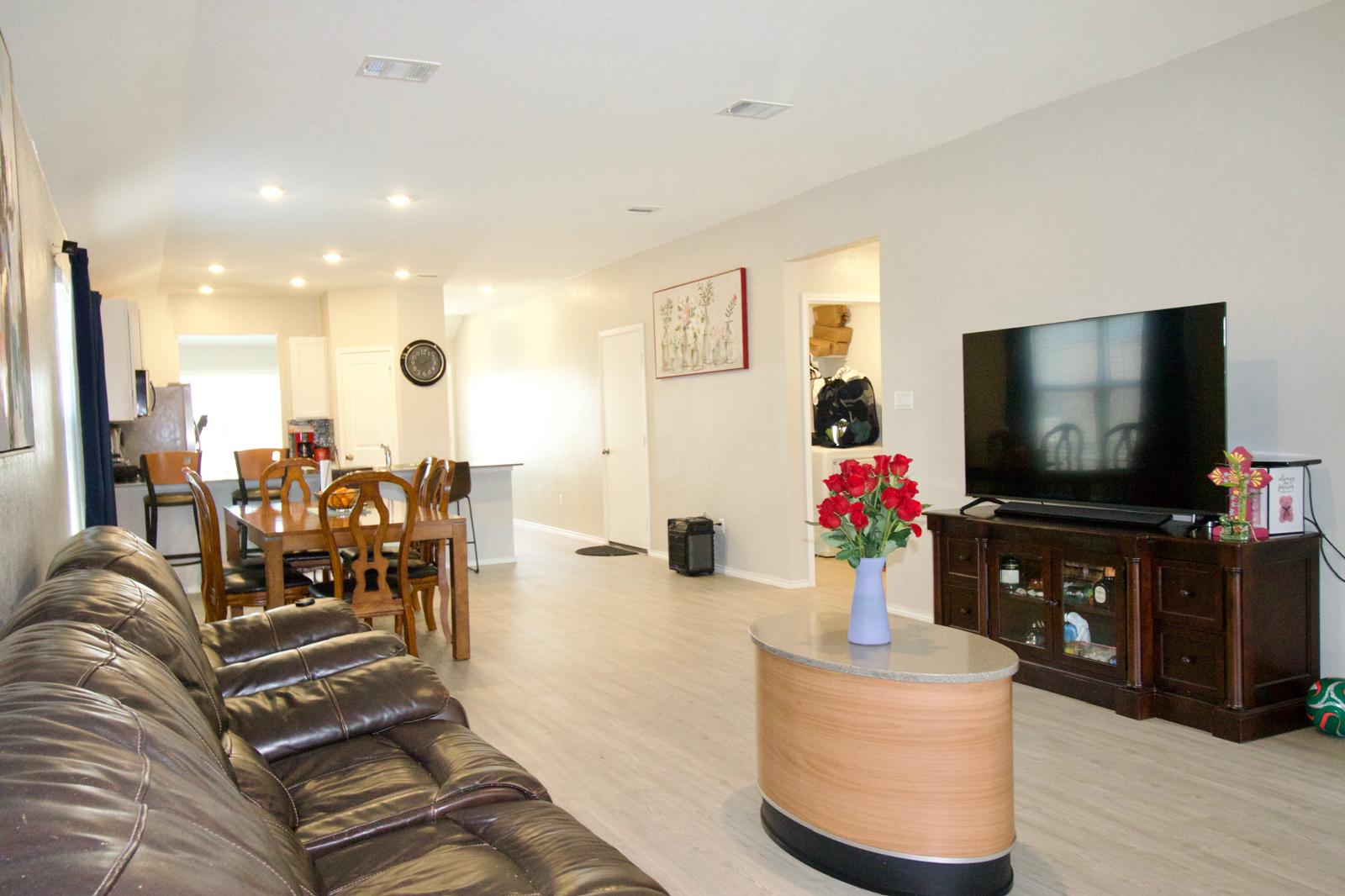 2545 Four Waters Loop Georgetown, TX 78628 - Photo 13 of 14 An open floorplan seamlessly connects the living and dining areas over sleek wood-finish flooring.