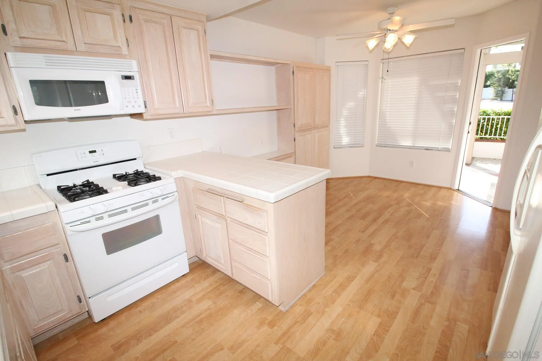 4190 Rhodes Way Oceanside, CA 92056 - Photo 11 of 25 a kitchen with white cabinets and white appliances