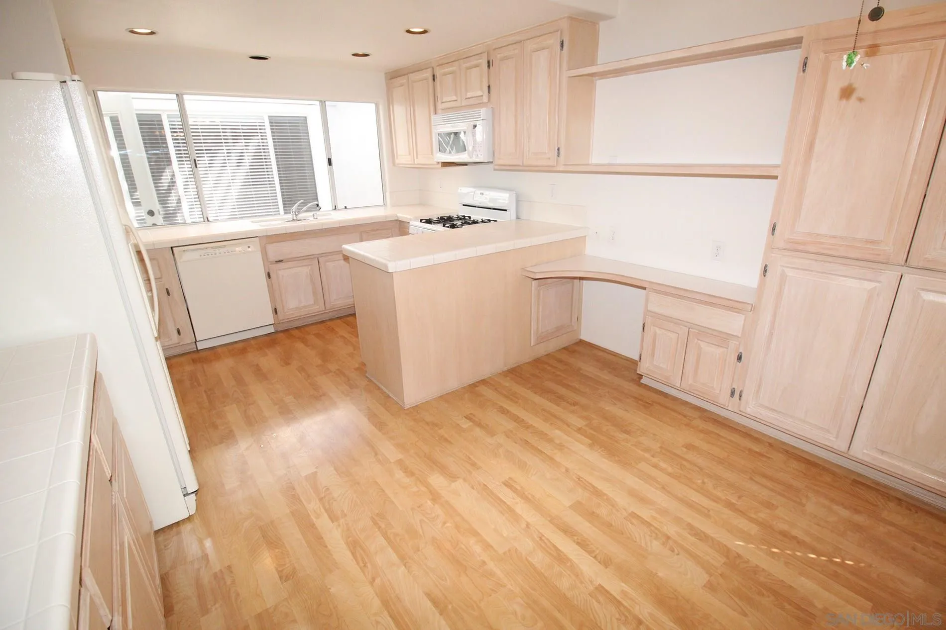 4190 Rhodes Way Oceanside, CA 92056 - Photo 8 of 25 a kitchen with a sink a stove a refrigerator and cabinets