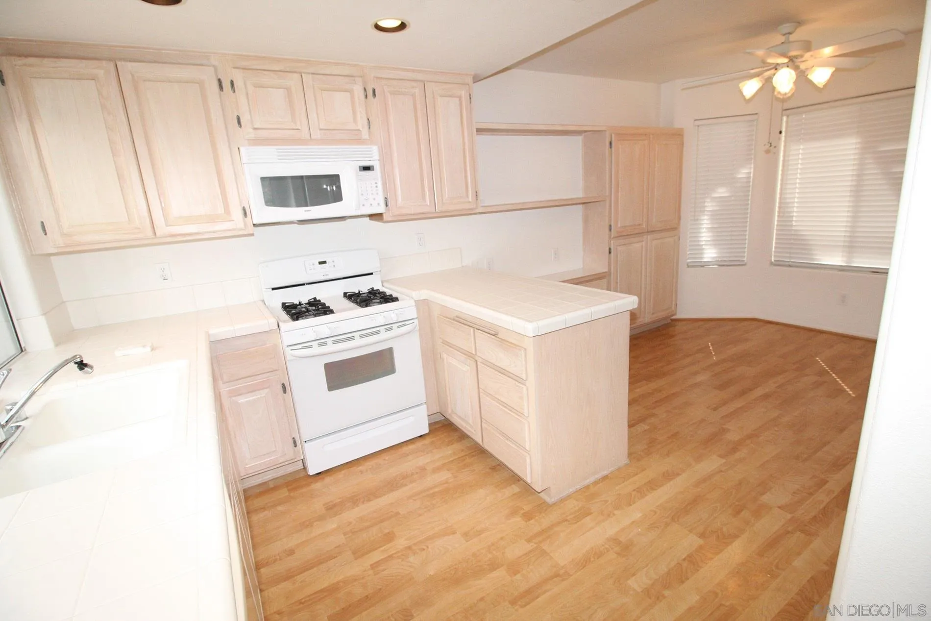 4190 Rhodes Way Oceanside, CA 92056 - Photo 9 of 25 a kitchen with a stove a sink and a microwave