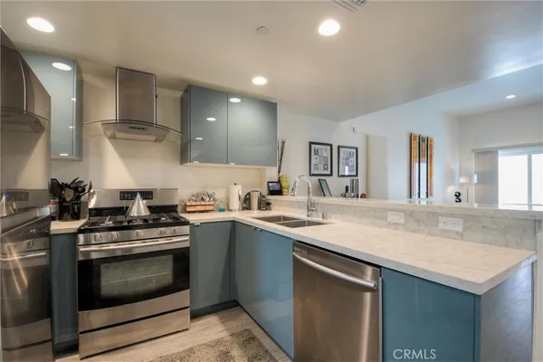 a kitchen with stainless steel appliances kitchen island granite countertop a refrigerator and a sink