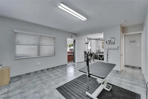 a room with gym equipment and wooden floor