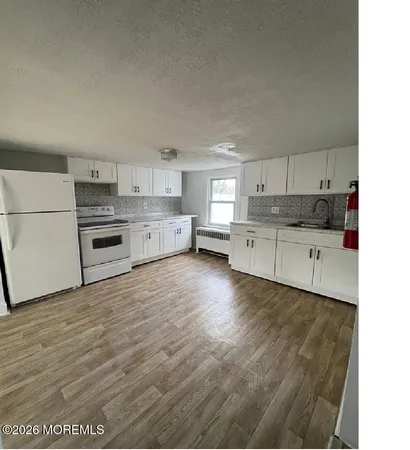 a kitchen with granite countertop a stove top oven and cabinets