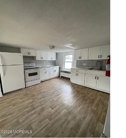 a kitchen with granite countertop a stove top oven and cabinets