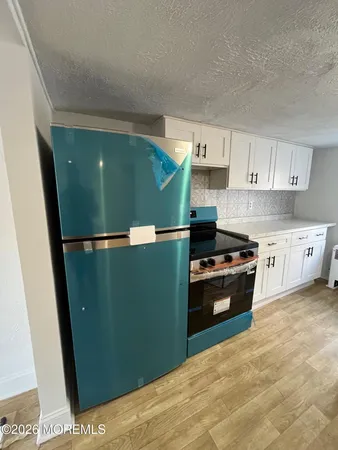 a kitchen with cabinets and a stainless steel refrigerator