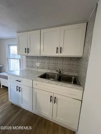 a kitchen with a sink a stove and cabinets