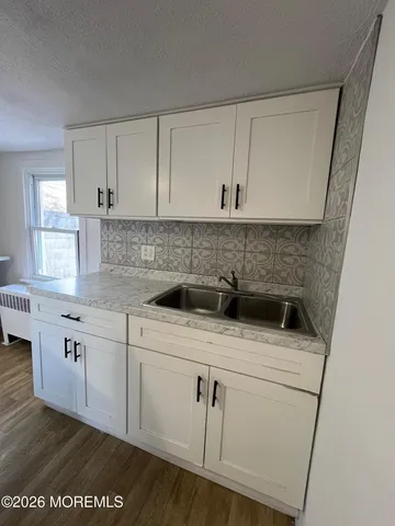a kitchen with a sink a stove and cabinets