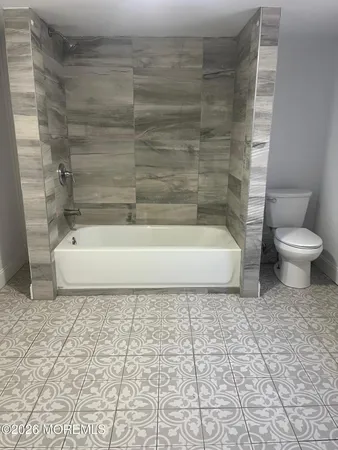 a bathroom with a white toilet and a shower