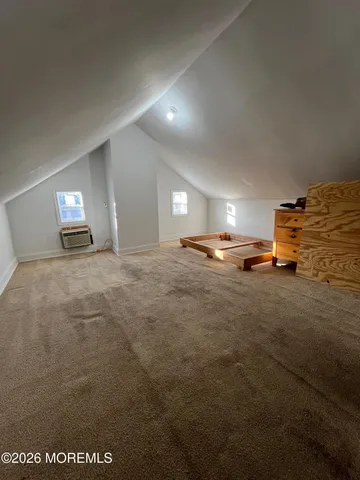 a spacious bedroom with a bed and wooden floor