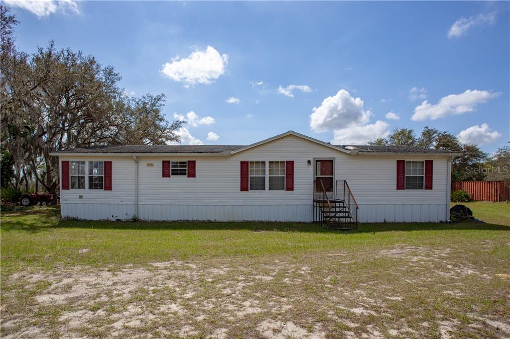 1140 Hopson Road Frostproof, FL 33843 - Photo 1 of 1 a front view of a house with a garden and yard