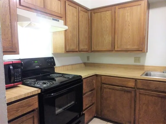 a kitchen with granite countertop a stove and a sink