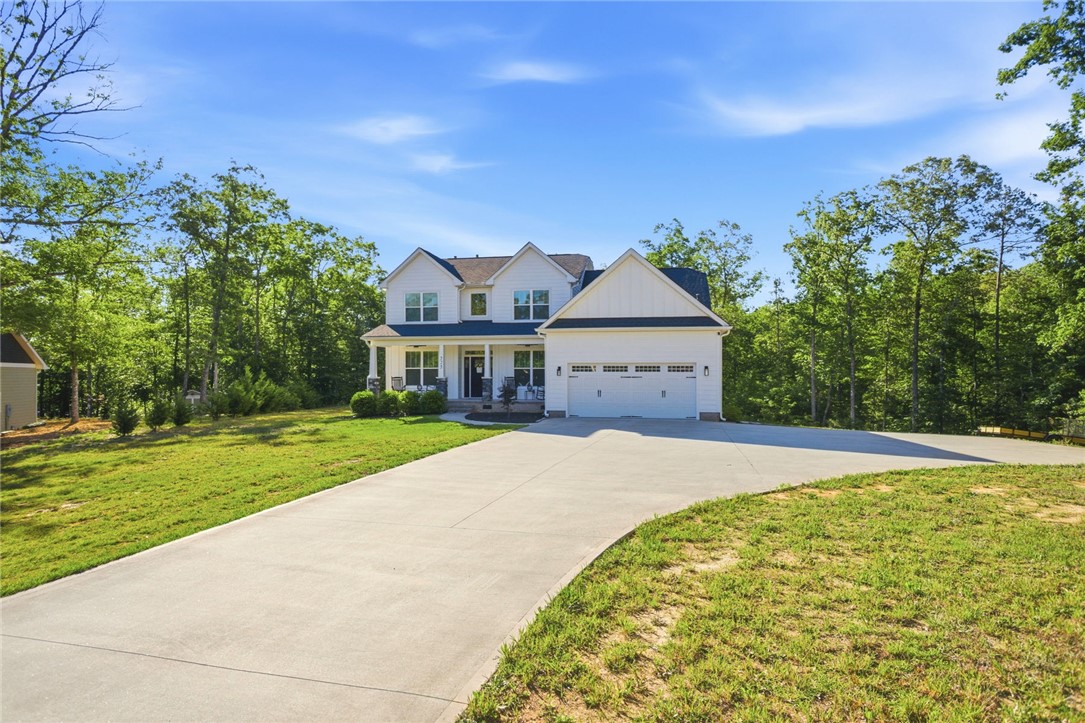 525 16th Circle Walhalla, SC 29691 - Photo 8 of 50 This charming residence features a spacious driveway and a welcoming front porch, nestled among lush trees.
