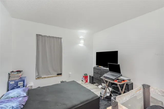 a bedroom with a bed and a computer on a desk