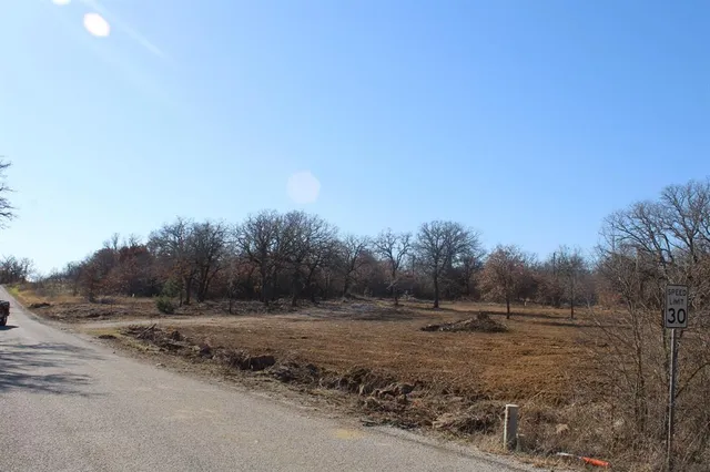 a view of a field with trees in background