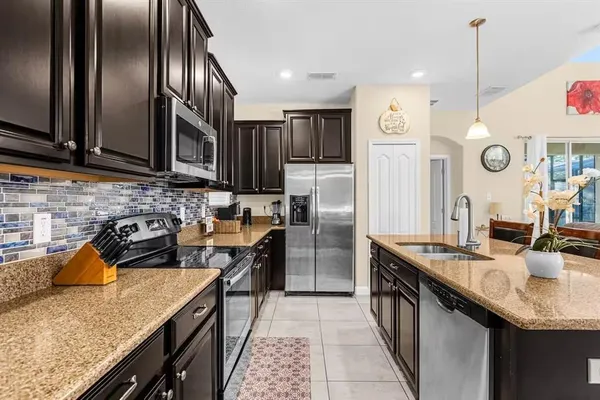 a kitchen with stainless steel appliances granite countertop a sink a stove and a refrigerator