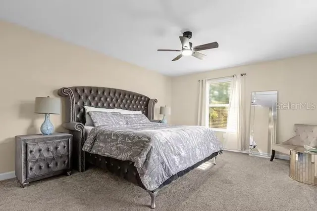 a bedroom with a bed a flat screen tv and a large window