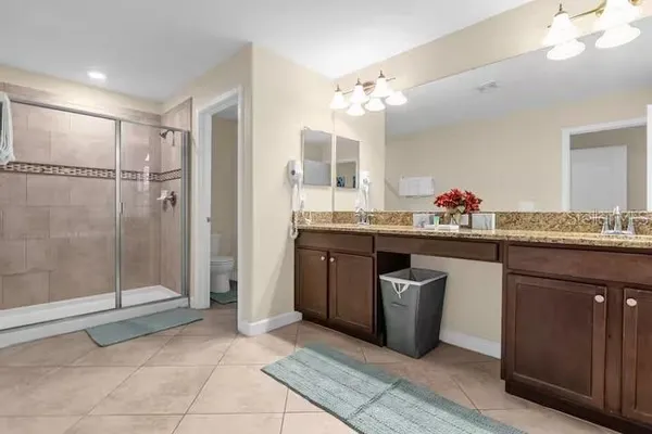 a bathroom with a granite countertop sink double vanity and mirror