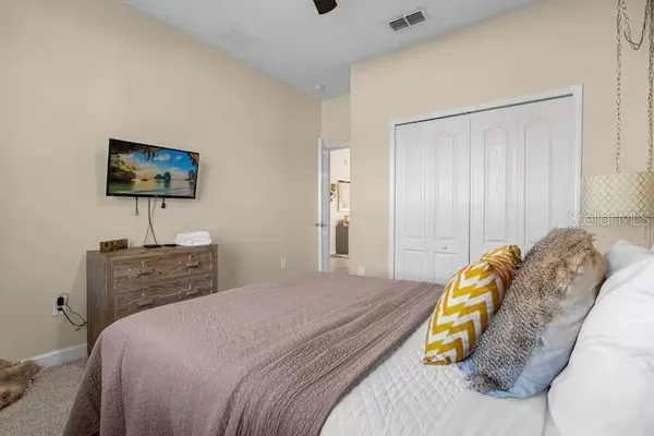 a spacious bedroom with a bed and a chandelier
