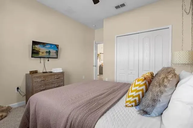 a spacious bedroom with a bed and a chandelier