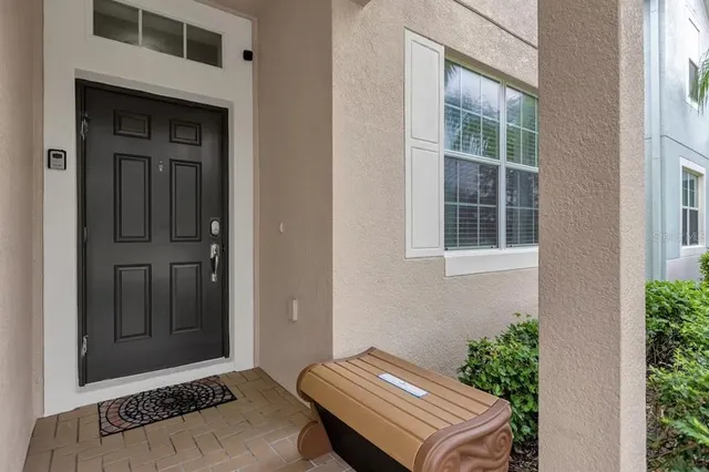 a backyard of a house with potted plants and brick wall