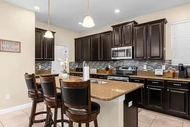 a kitchen with granite countertop wooden cabinets and stainless steel appliances