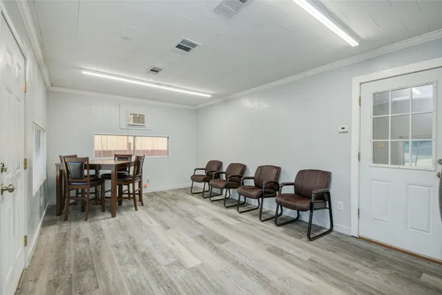 a dining room with furniture wooden floor a rug and a painting
