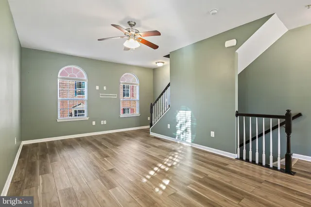 a view of a livingroom with wooden floor and a ceiling fan