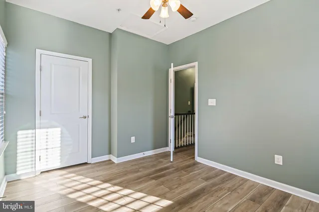 an empty room with closet and a chandelier fan