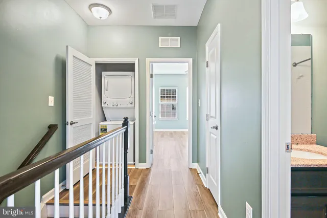 a view of a hallway with a livingroom and a hall with wooden floor