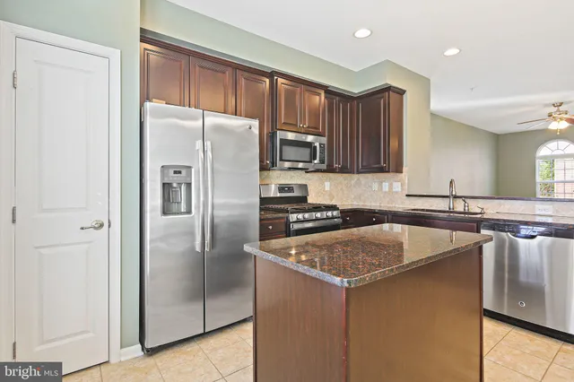 a kitchen with a refrigerator sink and cabinets