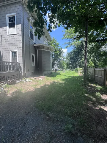 a view of a yard in front of a house with large tree