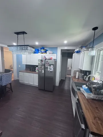 a kitchen with refrigerator and chairs