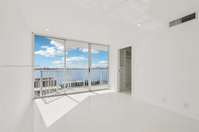 a view of an empty room with a floor to ceiling window and an empty room