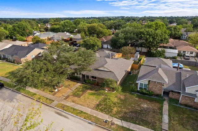 an aerial view of residential houses with outdoor space and trees